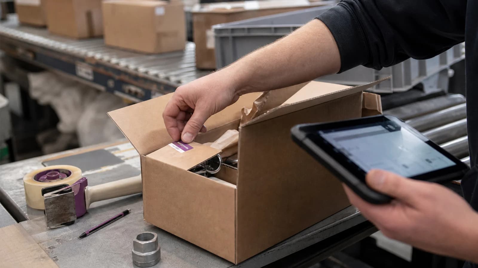Ein Mitarbeiter kennzeichnet einen Klärfall direkt an der laufenden Packstrecke